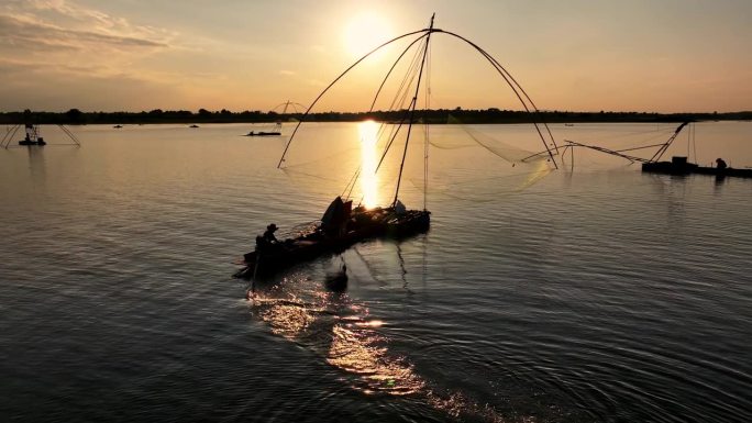 鸟瞰一名男子在日落时在泰国的湖中钓鱼。