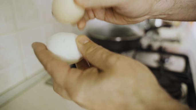 一名男子将煮熟的鸡蛋相互撞击以剥去蛋壳。