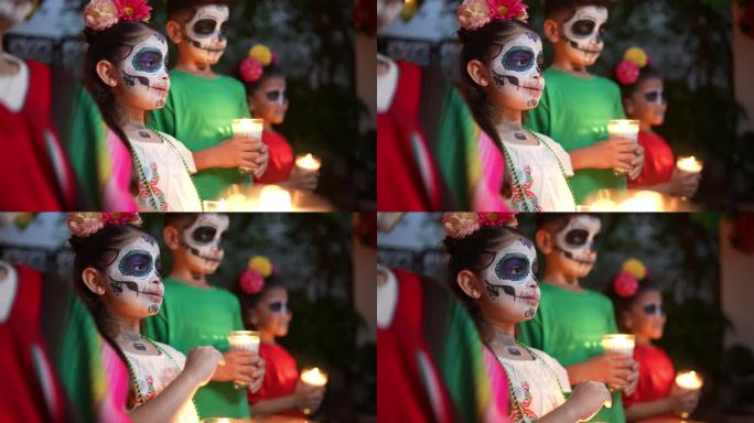 孩子们脸上画着糖骷髅，手持蜡烛庆祝亡灵