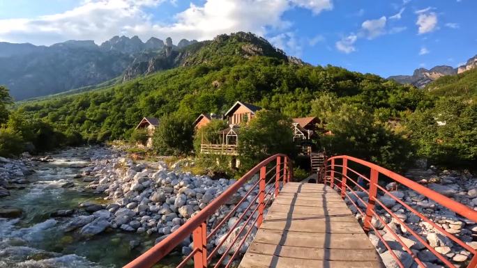 日落在瓦尔博纳河谷绿松石河上的红桥上，旁边是一座木屋，Theth国家公园，阿尔巴尼亚阿尔卑斯山脉