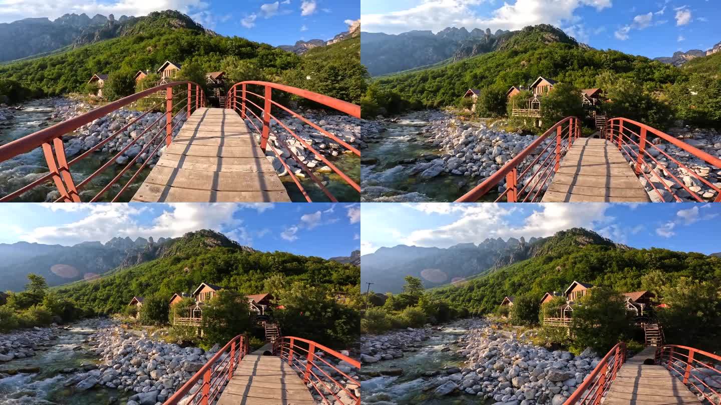 日落在瓦尔博纳河谷绿松石河上的红桥上，旁边是一座木屋，Theth国家公园，阿尔巴尼亚阿尔卑斯山脉