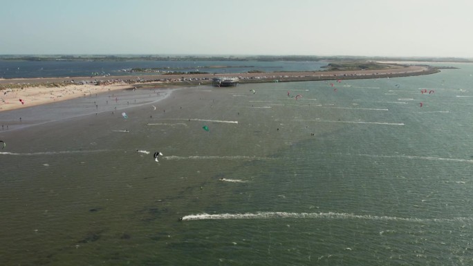 在荷兰泽兰的布劳维尔斯达明的风筝冲浪点，飞过风筝冲浪者。空中拍摄
