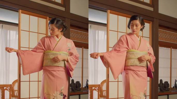 垂直屏幕:一个美丽的日本模特穿着粉红色和服的肖像。年轻迷人的女性站在家里的传统室内。看镜头的女人