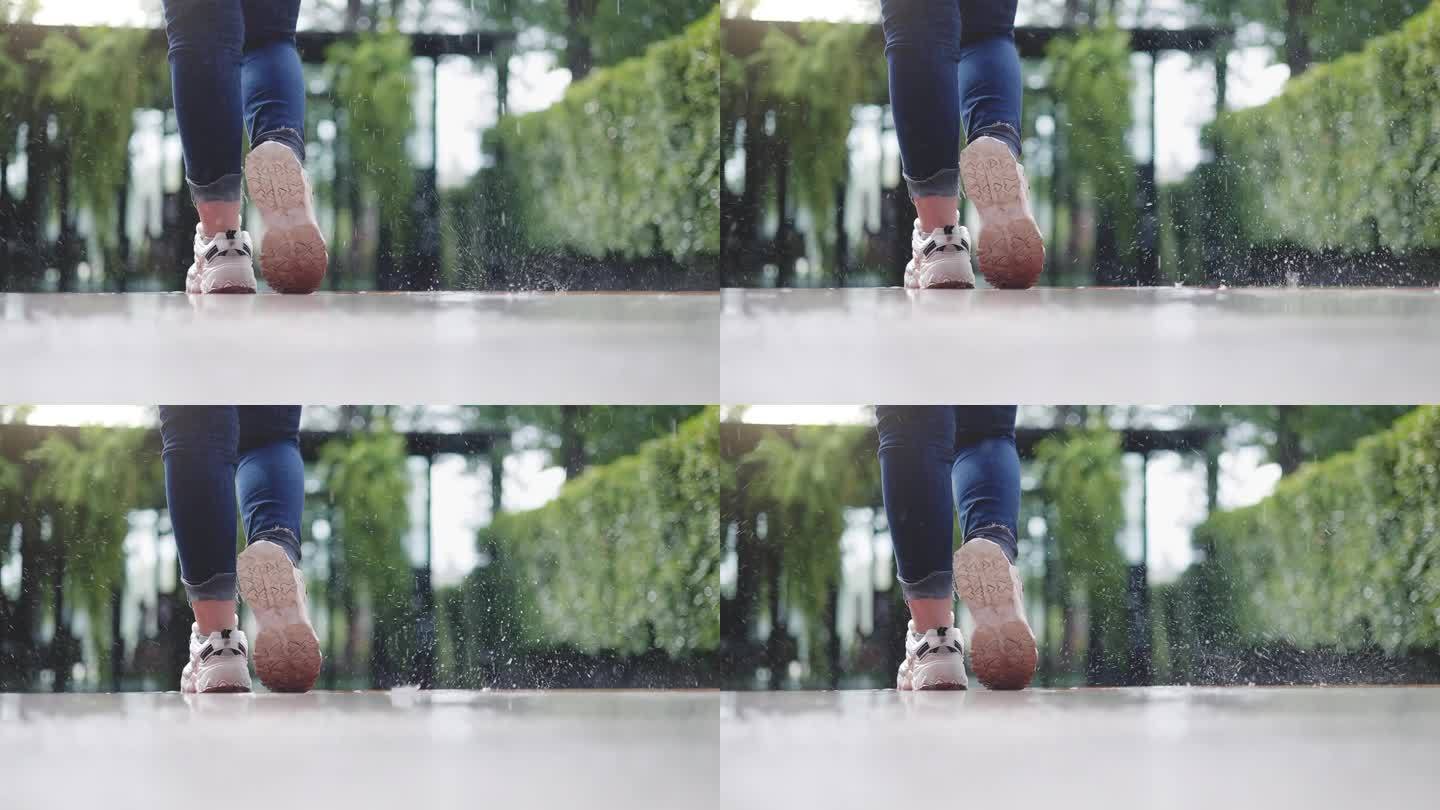 美丽的少女站在雨中的脚的特写镜头