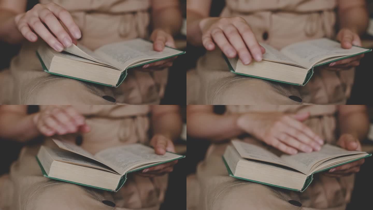 一个穿着古装的女孩在家里读一本古书。女性的手在翻动书页。关闭了。女人在看书。