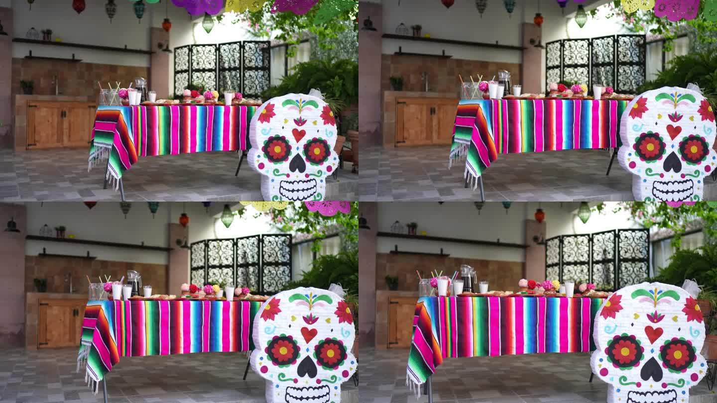 桌子上有装饰品，食物和糖头骨piñata为亡灵节