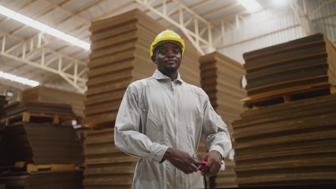 黑人男工程师在制造厂纸板造纸厂视察的肖像。