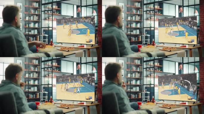 一个人坐在家里的沙发上看电视直播的篮球冠军赛。中年男性休息，观看在线流媒体的体育新闻报道，吃零食