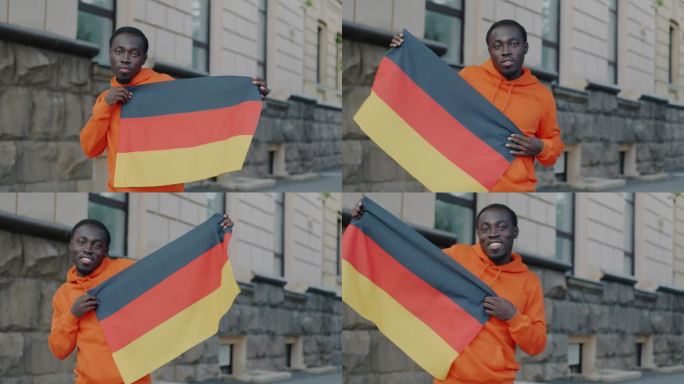 一个无忧无虑的非洲裔美国人拿着德国国旗跳舞，微笑着看着镜头的慢动作肖像