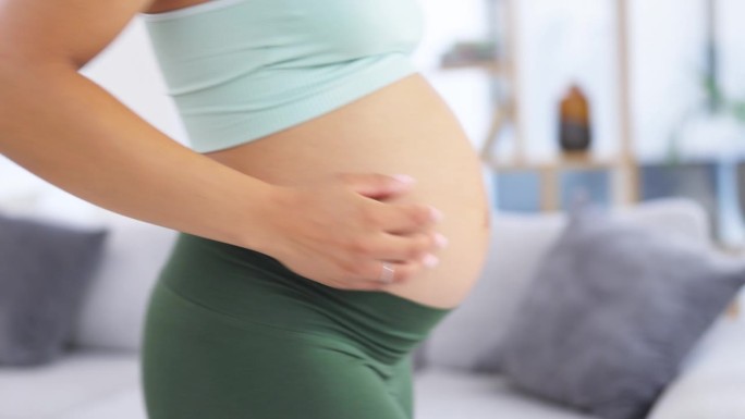 孕妇，在家按摩腹部和双手，带着宝宝的爱，支持或照顾放松。女性的笑脸、肚子或腹部发育与产妇、怀孕或房子