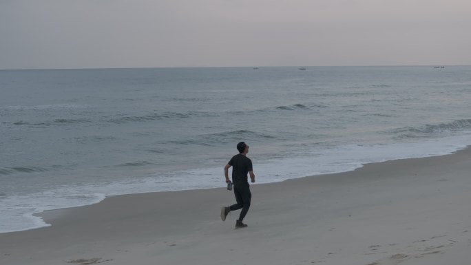 无人机航拍海边海浪沙滩男人跑步海岸线浪花