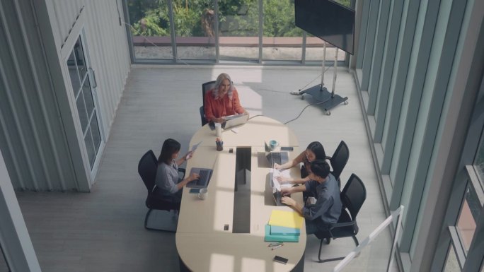 业务团队的俯视图在桌子上使用笔记本电脑和讨论找到解决方案在会议室。