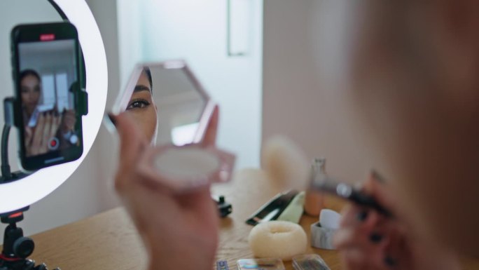 女美容师在镜子前化妆。博主记录面貌