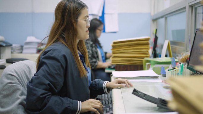 在办公室工作的女残疾人士使用扫描机扫描文件，以转换成数码文件输入电脑。口腔受损，唇裂，腭裂。
