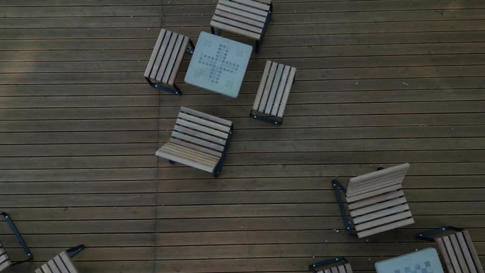 广场树下人行道上的摇椅。热带木材制成的单人躺椅。它们由棕色木板、板条、钢架和松木制成，很舒服