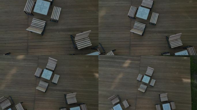 广场树下人行道上的摇椅。热带木材制成的单人躺椅。它们由棕色木板、板条、钢架和松木制成，很舒服