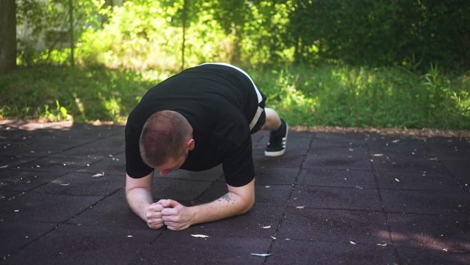 男性在户外健身房做平板支撑练习