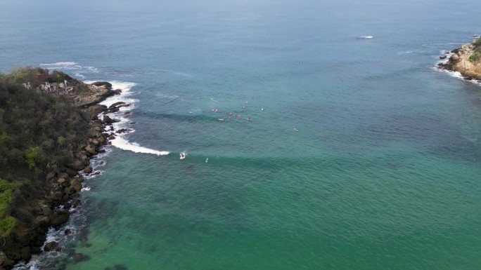 鸟瞰图冲浪者在墨西哥瓦哈卡州埃斯孔迪多港的卡里扎利略海滩乘风破浪