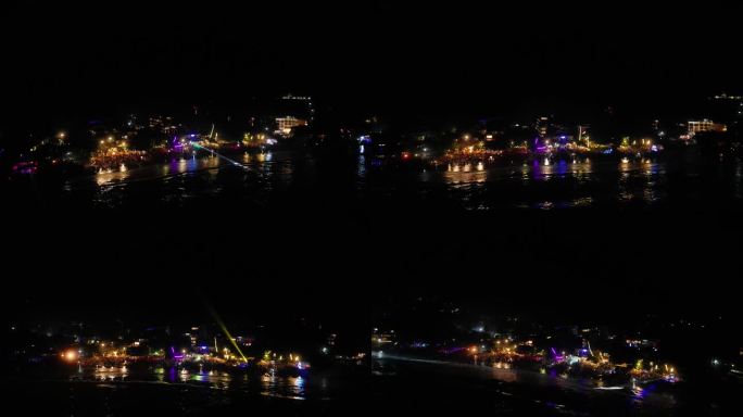 几排海边的海滩夜总会从水上鸟瞰。海滨咖啡馆和餐馆在夜晚的彩灯，人群在海上迪斯科跳舞在圣诞庆祝派对无人