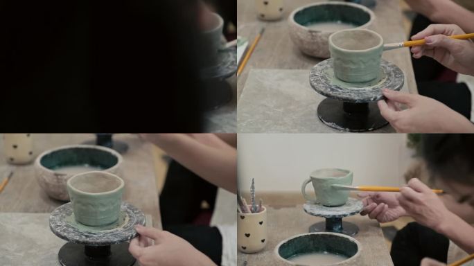 在工作室里，人们在陶器轮上给陶土马克杯上色