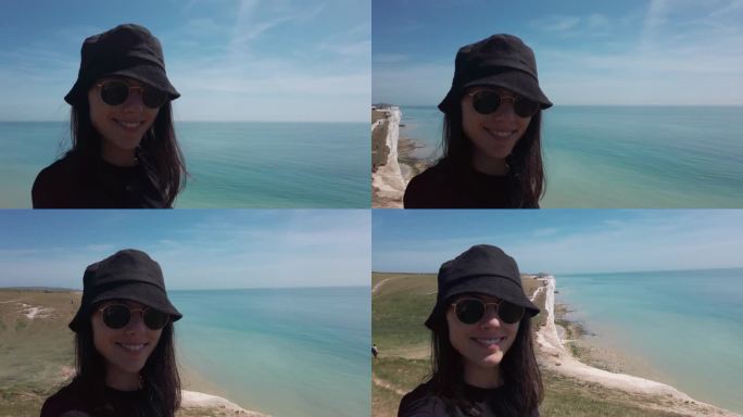 英国七姐妹餐厅快乐女游客的自拍。女性对着镜头微笑，戴上帽子和眼镜