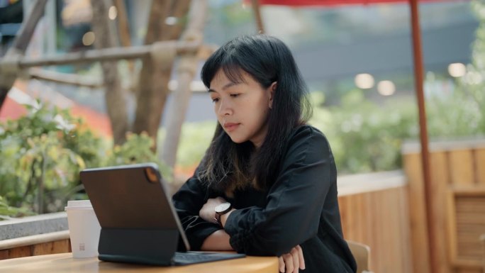亚洲女商人早上在咖啡店用笔记本电脑打字发邮件