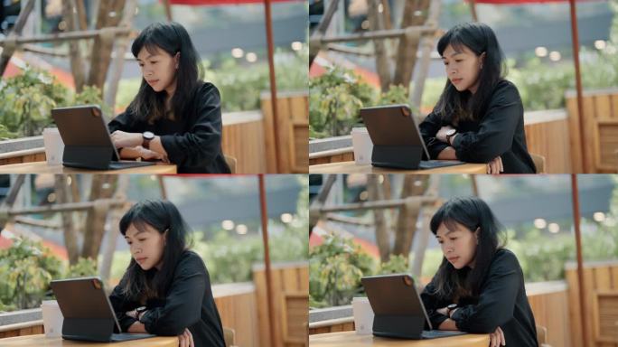 亚洲女商人早上在咖啡店用笔记本电脑打字发邮件