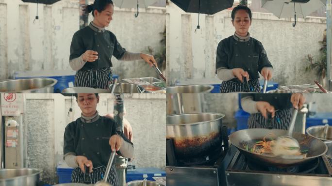 正宗的泰国食物准备由女厨师-烹饪泰式炒粉在曼谷街头市场。