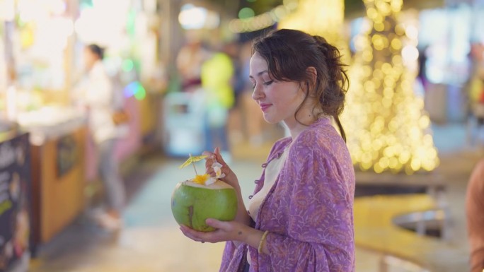 一名女子在曼谷夜市吃椰子冰淇淋