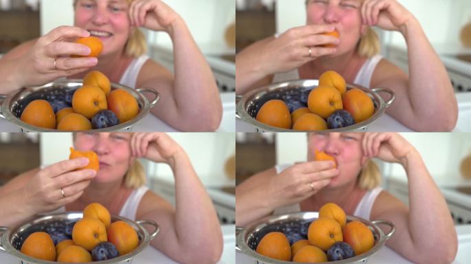胖乎乎的金发女郎狼吞虎咽地吃着一颗杏子