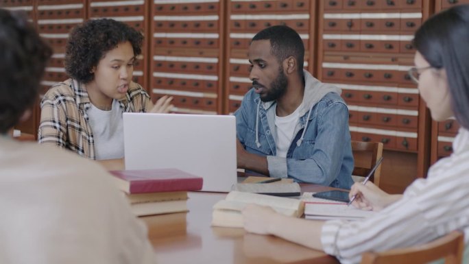 在大学里，一群学生一起用笔记本电脑聊天，看着屏幕