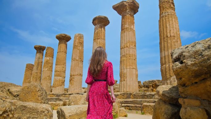 一名女游客参观意大利西西里岛的古色古香的赫拉克勒斯神庙。