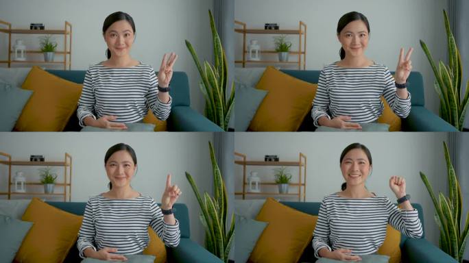 亚洲女人开心地微笑着，用手指坐在家里的沙发上数数。