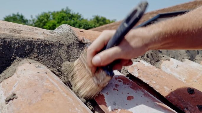 男子手刷湿水泥从陶土瓷砖墙关闭慢莫