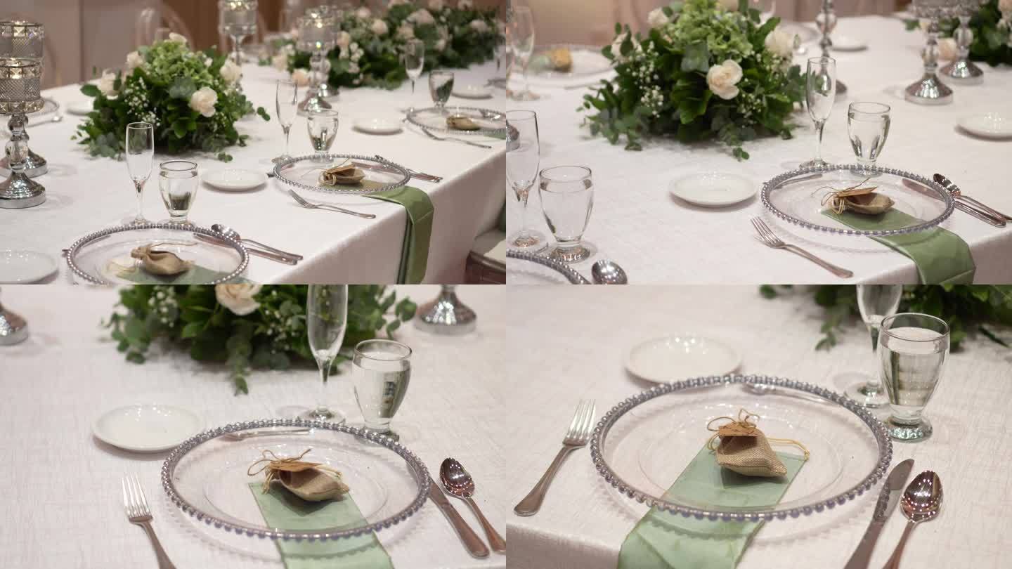 用鲜花装饰的婚礼餐桌布景。婚礼花艺。宴会桌供客人使用。玫瑰、尤加利树叶的香味
