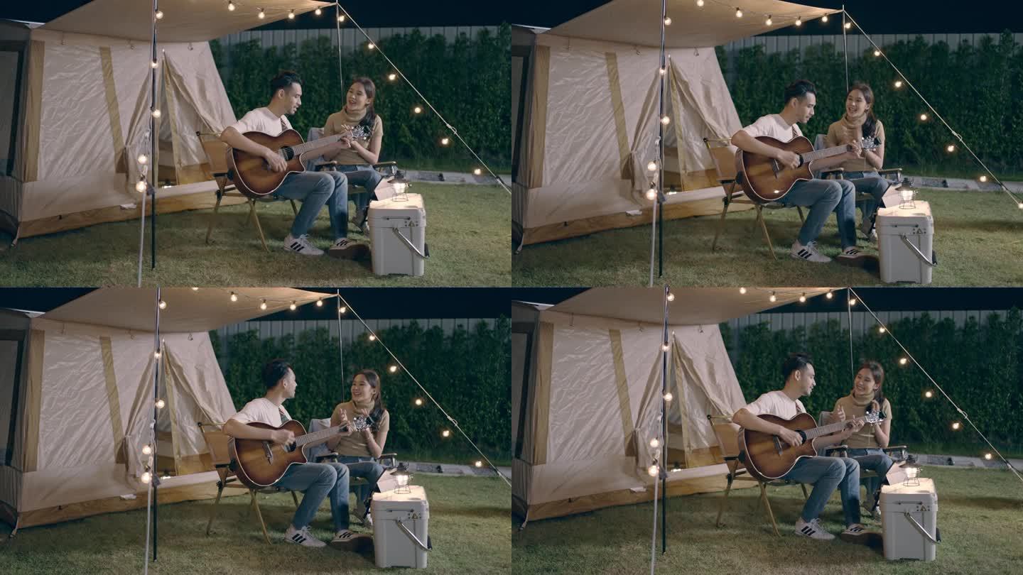 亚洲年轻夫妇在度假露营时弹吉他