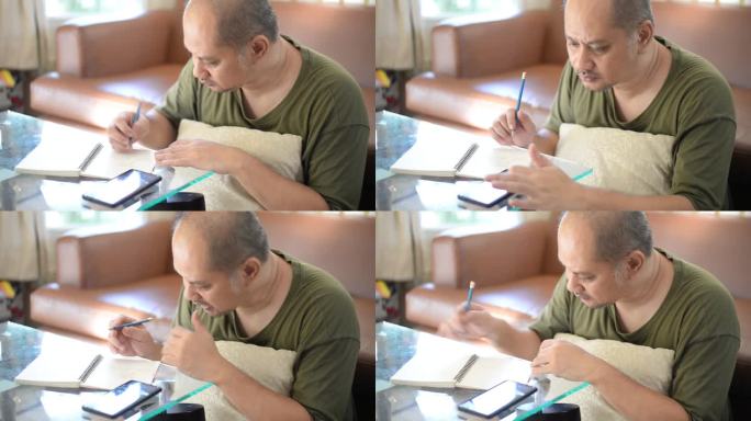 亚洲人在笔记本上写字和画画