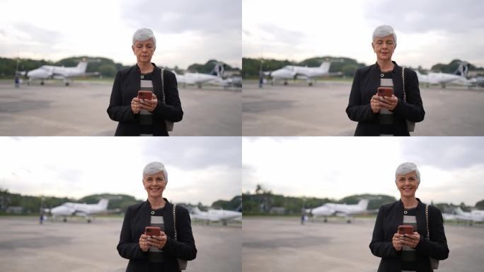 一位资深女商人在机场使用手机的肖像