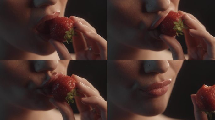 性感的女人用红色的口红工作室拍摄咬一口草莓和品尝