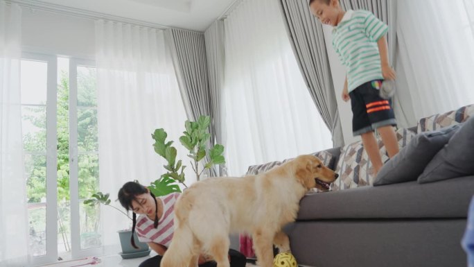 妈妈和儿子在家里玩狗玩得很开心