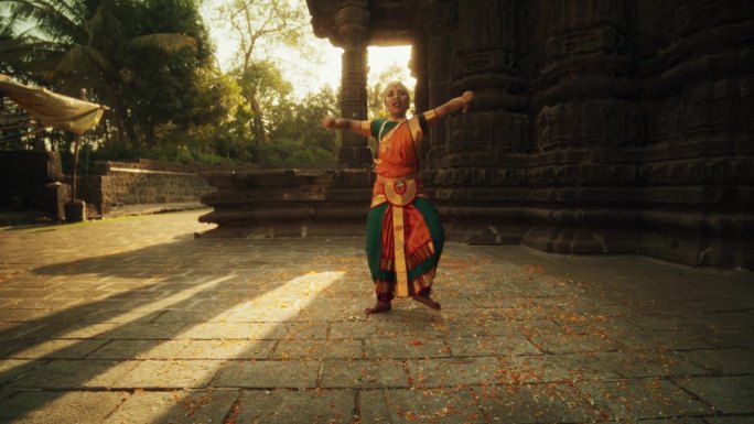 一个印度女孩在一座古老的寺庙里练习婆罗那塔yam艺术的戏剧表演。富有表现力的年轻女性穿着五颜六色的传