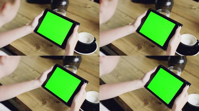 绿屏手在咖啡厅使用数码平板触屏设备ipad