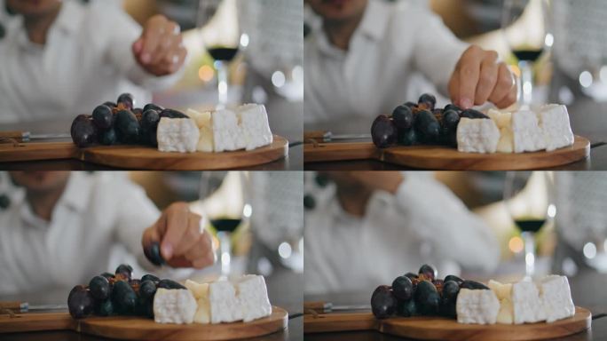 美味的奶酪开胃菜躺在木板上特写。拿葡萄的人。