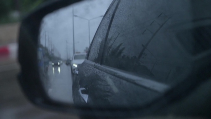 傍晚和雨天行驶在路上的汽车近景后视镜，慢动作场景