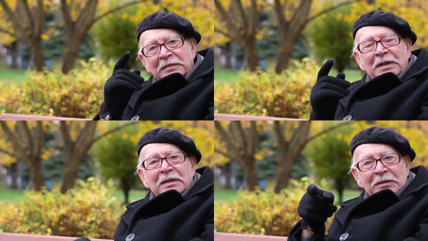 一位睿智的老人坐在秋天公园的长椅上说了些什么。