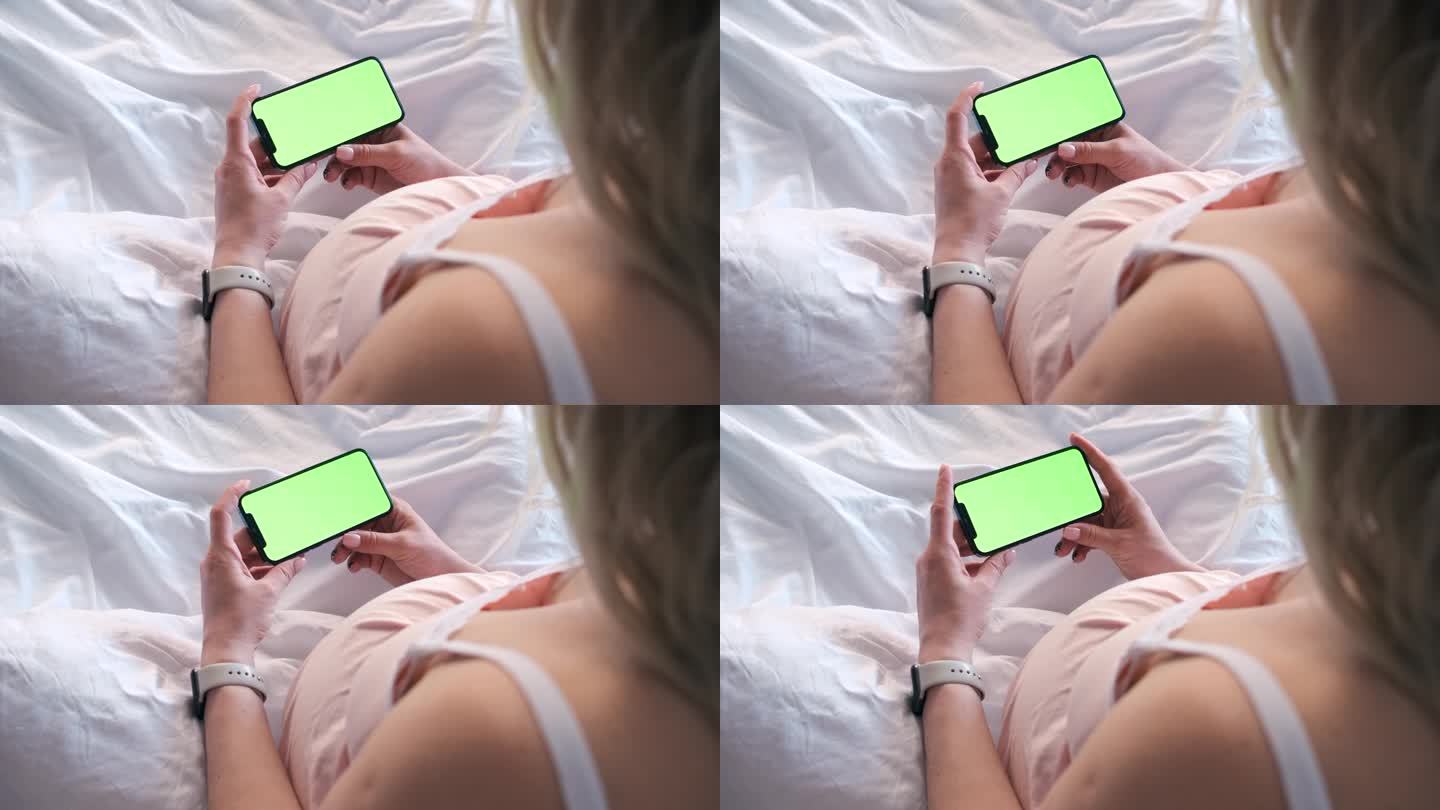 孕妇躺在床上看手机