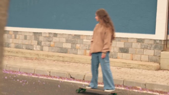 年轻女子沿着街道滑滑板