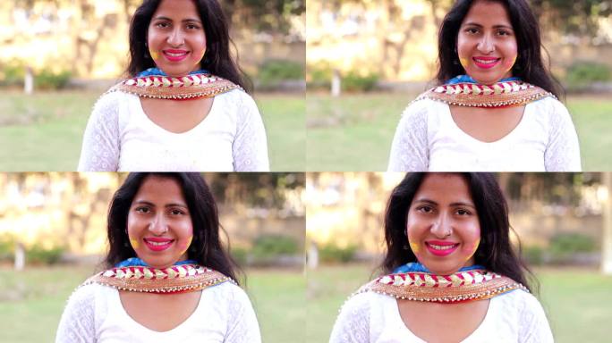 年轻的印度妇女在胡里节上露出露齿的微笑