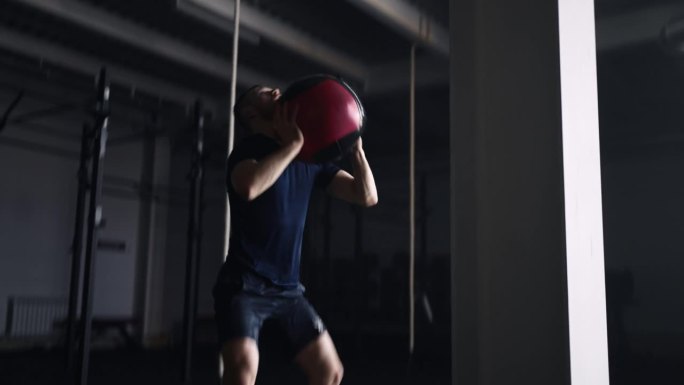 举重运动员在健身房单独训练，投掷重球，在健身中心进行力量训练