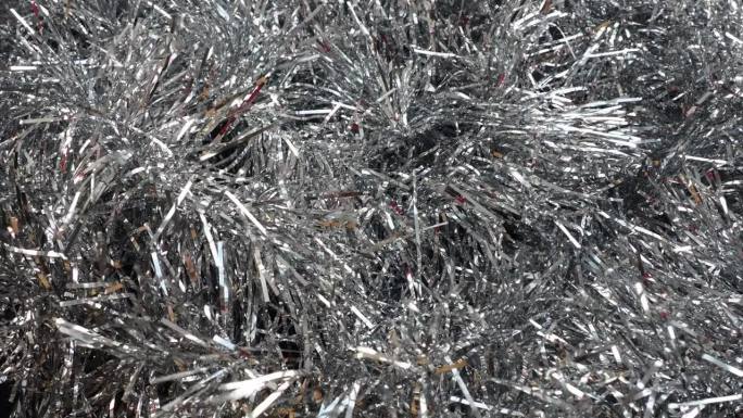 银光闪闪的金属丝在风中或风中飘动。圣诞节和新年装饰圣诞树，室内或冬季街道。圣诞树的针叶在空气的呼吸下